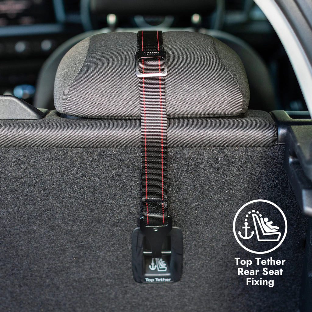 A black car rear seat top tether strap with red stitching and a silver buckle, shown attached to the headrest of a car seat. A circular graphic overlay on the bottom right reads 'Top Tether Rear Seat Fixing' with an icon.