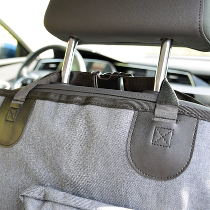 Gray car organizer attached to a car's headrest with a blurred background