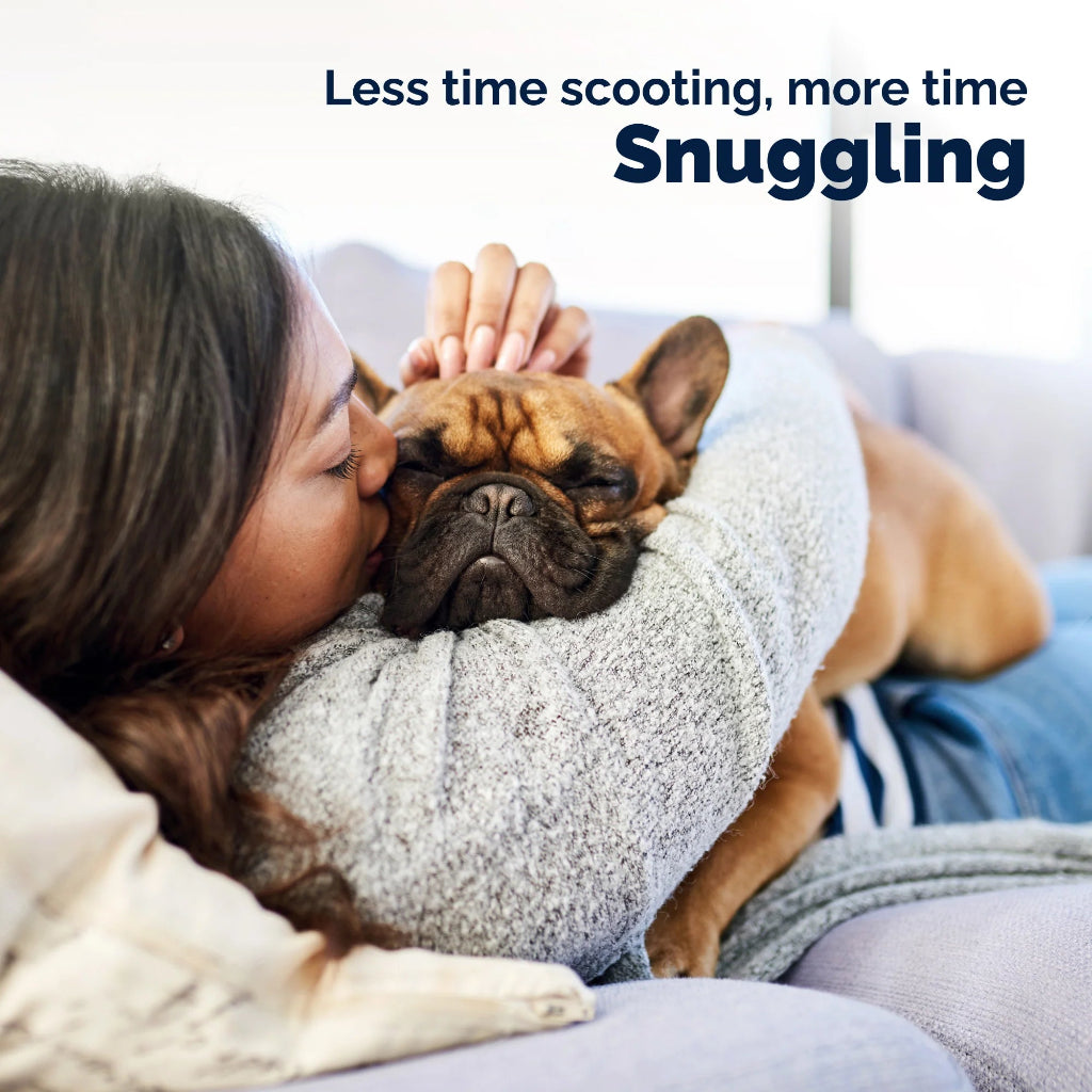 Woman snuggling with a dog on a couch, with text 'Less time scooting, more time Snuggling'.