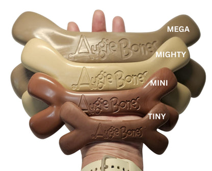 Stack of Augie Bones dog chew toys in different sizes held by a hand.