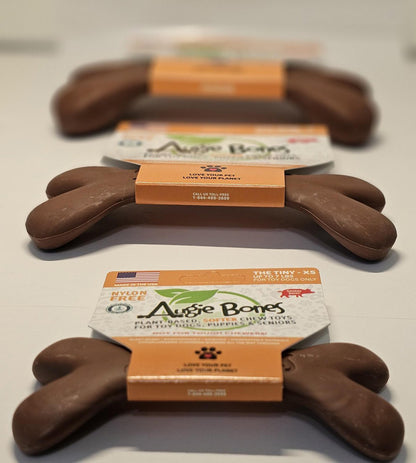 Dog chew toys shaped like bones with packaging on a white surface