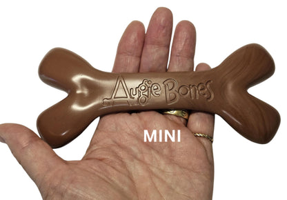Brown dog toy shaped like a bone with 'Augie Bones' branding held in a hand.