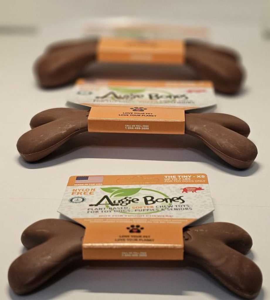 Dog chew toys shaped like bones with packaging on a light background