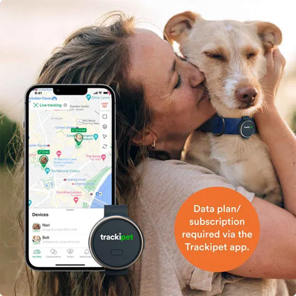 Woman holding a dog with a Trackipet device and app displayed on a smartphone.